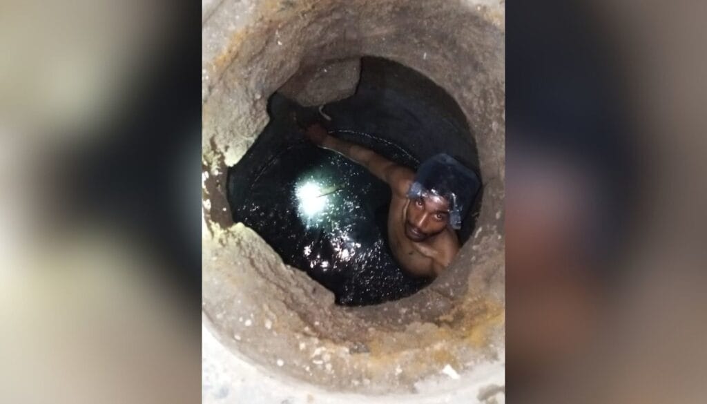Akash Masih rengjør en kum i Johar Town i Lahore med plastpose over hodet som beskyttelse mot kloakkslam.