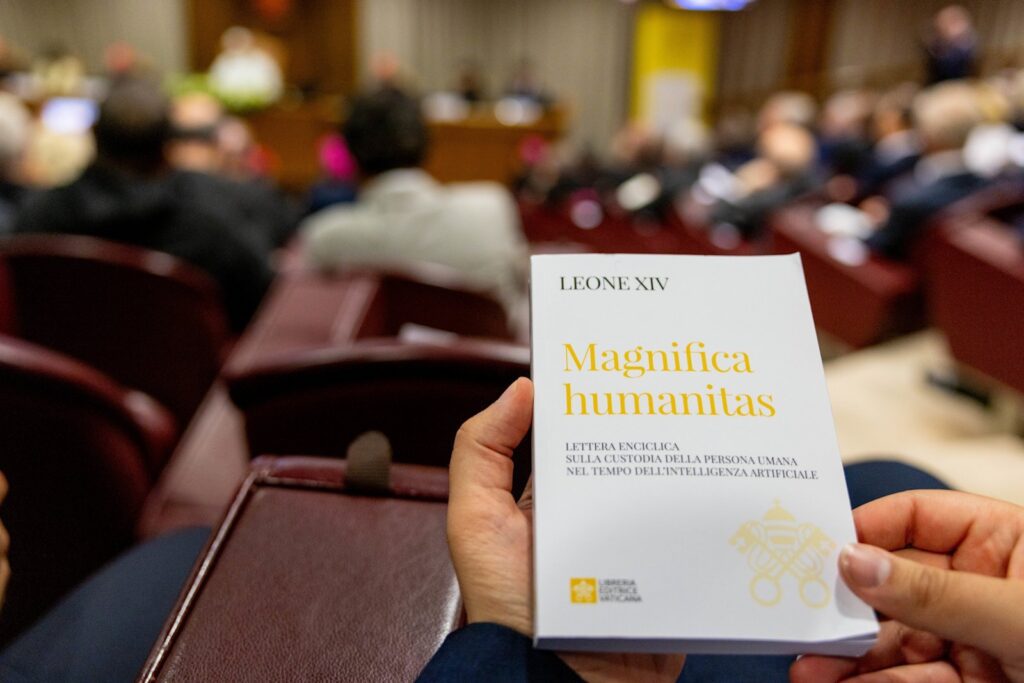 Et trykt eksemplar av Magnifica Humanitas holdes under presentasjonen i Vatikanets nye synodehall.