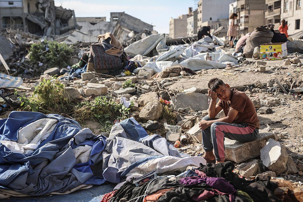 Palestinsk gutt sitter blant ødeleggelsene etter et israelsk militært angrep mot bygninger og telt for fordrevne familier i Gaza by.
